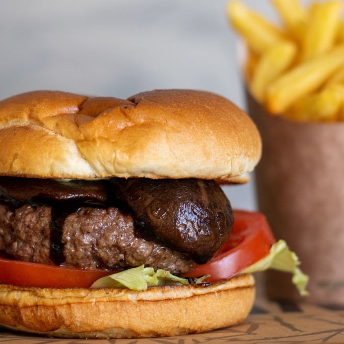 Beef burger with shiitake mushrooms, tomatoes, lettuce and fries