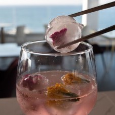 Pomegranate Infused Tanqueray Gin with edible flowers and rose water spray